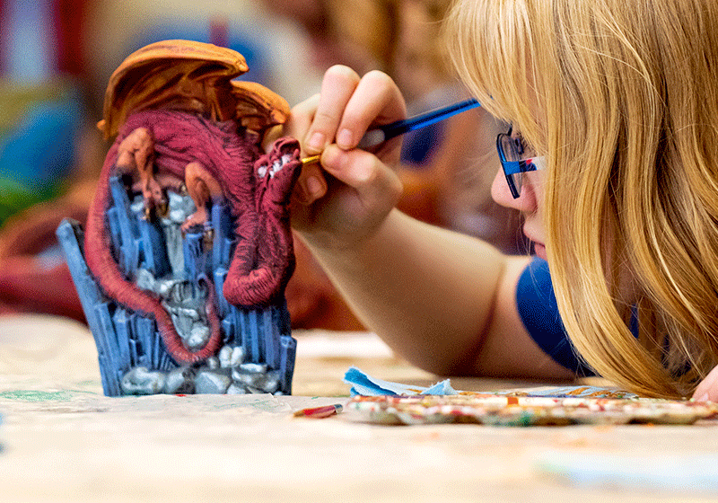 Youth painting a dragon statue